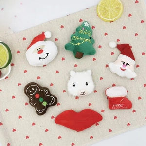 Macro detail of plush Christmas accessories including Santa and ginger man charms
