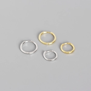 Detail view of classic silver and gold geometric hoop earrings in different sizes