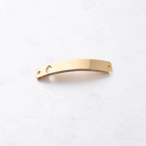 Macro view of golden stainless steel curved connector with heart cutout and brushed texture