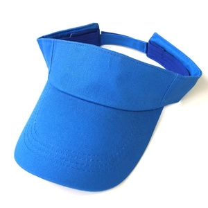 Detail van de blauwe katoenen zonneklep met kepertextuur en verstelbare klittenband