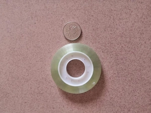 Gros plan d'un petit ruban adhésif transparent avec un noyau en plastique blanc