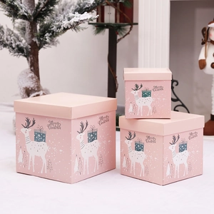 Three pink Christmas nesting gift boxes with reindeer motifs for holiday window decor