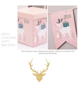 Detail of pink Christmas gift boxes with reindeer motifs and glittery gold antlers