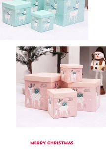 Pink and mint green Christmas gift boxes with reindeer illustrations and festive decor
