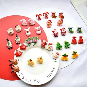 Macro shot of colorful resin Christmas charms featuring Santa, snowman, and reindeer motifs