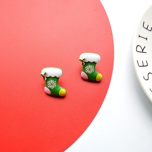 Macro detail of festive forest green Christmas stocking earrings with snowflake pattern