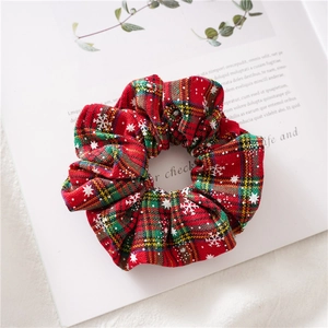 Close-up of Christmas plaid scrunchie with white snowflakes on red and green fabric