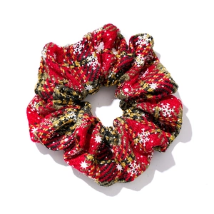 Red plaid Christmas hair scrunchie with white snowflake patterns on a plain white background