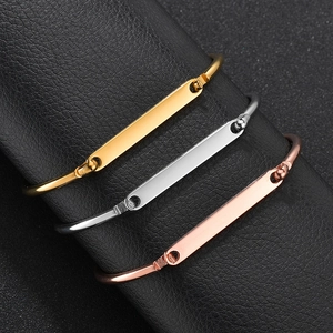 Polished gold, silver, and rose gold bar bracelets on a black leather jewelry roll