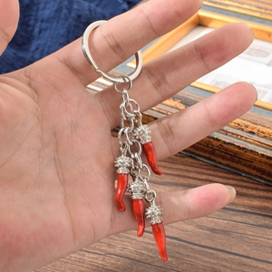 Creative silver keychain with four red cornicello chili pendants on a metal ring