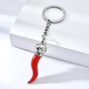 Detailed macro view of a red Italian horn keychain with a silver crown on a white stand