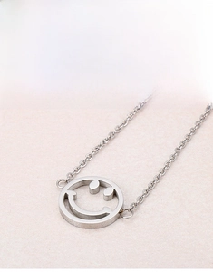 Nahaufnahme des silbernen Smiley-Anhängers an einer feinen Edelstahl-Gliederkette