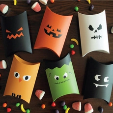 Overhead view of colorful Halloween pumpkin and ghost pillow gift boxes on wood