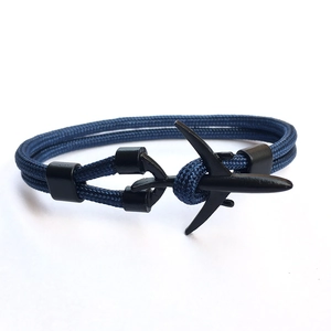 Blue woven paracord bracelet with black metal airplane clasp on white background