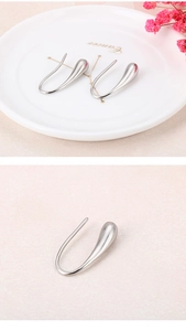 Macro shot of silver teardrop earrings in minimalist stainless steel polished finish
