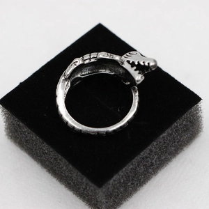 Vintage silver crocodile ring with open band design on a textured black display