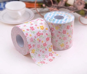 Close-up of printed toilet paper rolls with pink floral patterns in a home setting