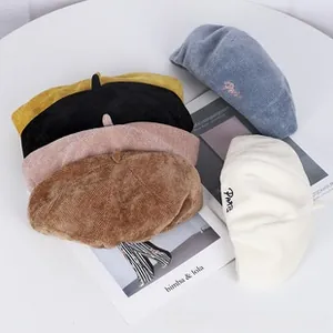 Detail view of stylish corduroy beret hats in various colors for autumn fashion.