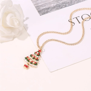 Vue détaillée d'un collier pendentif sapin de Noël avec émail coloré sur une chaîne dorée