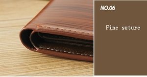 Détail du portefeuille homme marron avec texture grain de bois et couture fine orange