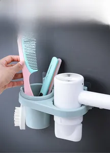 Wall-mounted hair dryer holder with storage cup and side hook on a dark wall