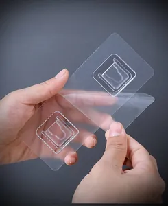 Macro detail of transparent adhesive hooks for wall mounted bathroom hair dryer racks