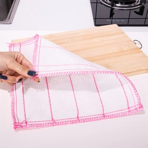 Absorbent white dishcloth with pink grid pattern held by hand on kitchen countertop