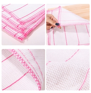 Macro shot of white cleaning cloth with pink stitching and textured grid pattern detail
