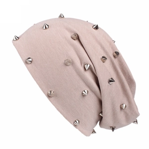 Bonnet tombant punk beige clair avec rivets coniques en métal argenté sur fond blanc
