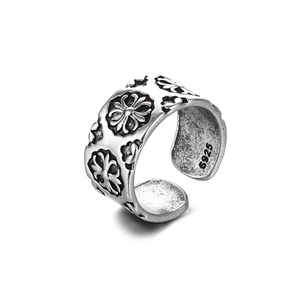 Detalle macro de anillo de plata vintage con grabado S925 y relieve de flores cruzadas