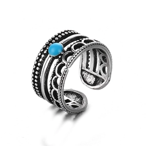 Primer plano de un anillo de serpiente punk vintage con turquesa y acabado plateado