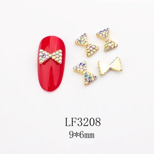 Détail macro de breloques nœud 9x6mm en alliage doré avec strass colorés pour ongles