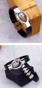 Detail view of men's black leather bracelet with metallic skull and oval buckle clasp