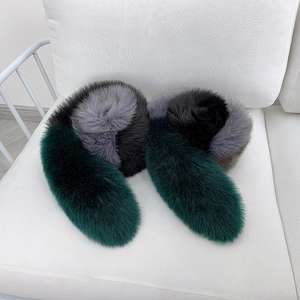 Luxurious patchwork fox fur scarf in dark green and grey on white fabric background