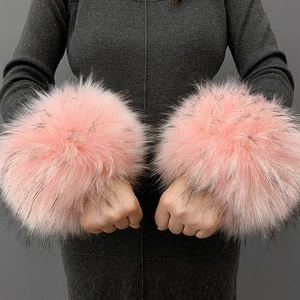 Close-up of fluffy pink faux fur wrist cuffs shown on model for cold weather accessories