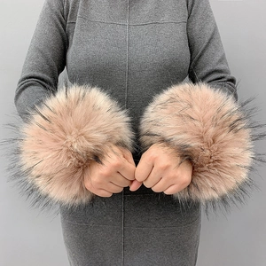 Detail of khaki faux fur wrist cuffs with black tips worn on sleeves for winter