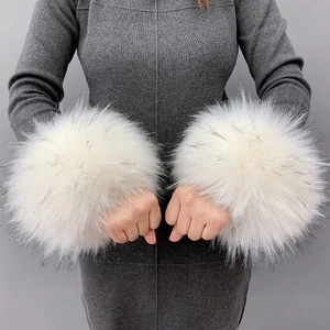 Close-up of fluffy white faux fur wrist cuffs worn over grey knit sleeves detail
