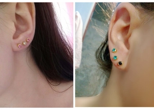 Detailed view of multi-color stud earrings with gold plating on earlobe and cartilage
