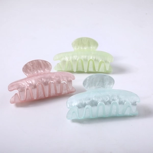 Close-up of three acetate hair claws in pastel pink, mint green and blue with pearl texture