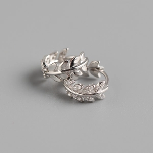 Macro shot of silver olive leaf earrings featuring sparkling diamond accents on S925 silver