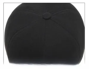Close-up of the six-panel stitching and top button on a winter baseball cap for men