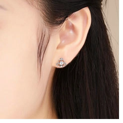 Close-up of a silver heart stud earring with zircon on model ear for daily wear
