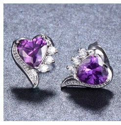 Detail of heart-shaped purple gemstone earrings with silver accents and tiny diamonds