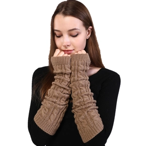 Detail of cable knit pattern on brown fingerless gloves with soft texture focus