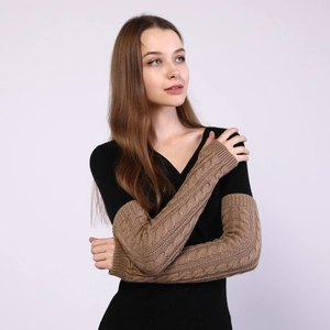 Detail of cable knit pattern on long fingerless wool gloves in dark khaki coffee color