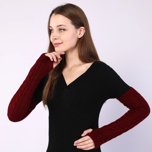 Close-up of cable knit wine red sleeves and ribbed black fabric texture details