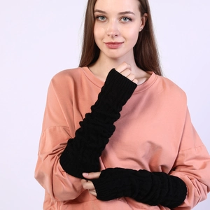 Detail of black cable knit long fingerless gloves showing the textured arm warmer texture