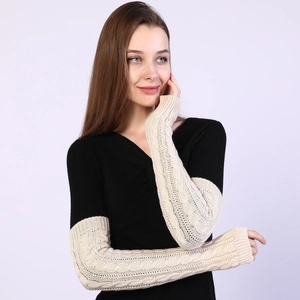Detailed cable knit texture on beige arm warmers with a stylish fingerless design