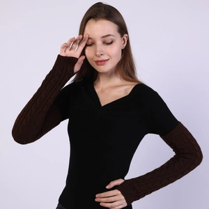 Close-up of dark brown cable-knit arm warmers with detailed thick stitch texture