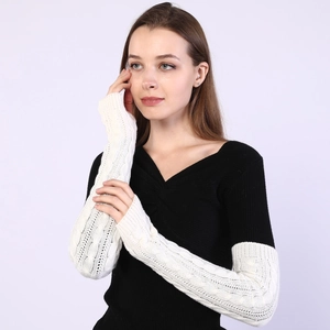 Detailed texture of cream knit cable pattern arm warmers for autumn fashion styling